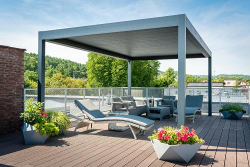 einen Pavillon auf einer Terrasse mit Stühlen und Blumen in der Unterkunft Hotel J.J. Darboven in Rumia
