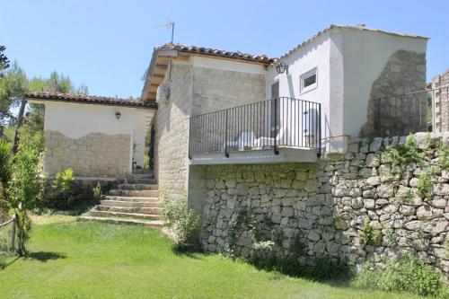 a house with a stone wall and a balcony at Locanda Angelica in Giarratana