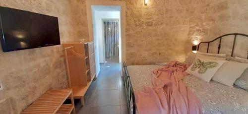 a bedroom with a bed and a flat screen tv at Locanda Angelica in Giarratana