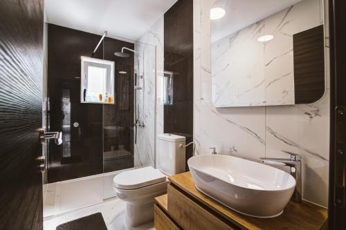 a white bathroom with a sink and a toilet at Apartman Izzy in Senj