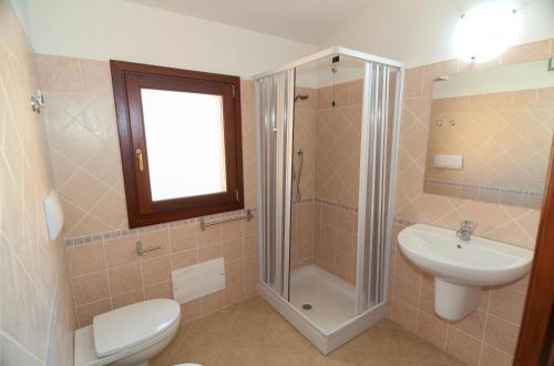 uma casa de banho com um chuveiro, um WC e um lavatório. em Corte di Gallura em Budoni