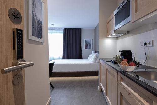 una cucina con lavandino e un letto in una camera di Five Resort Cholet Centre a Cholet