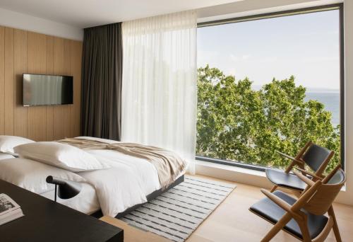 a bedroom with a bed and a large window at briig boutique hotel in Split