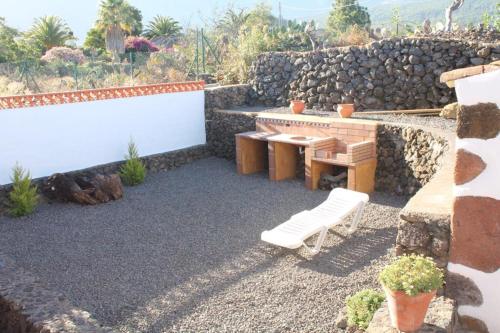 a patio with a table and a bench and a stone wall at Casa Gusber I in El Paso