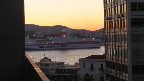 a large ship in the water in a city at ΜΕ ΘΕΑ ΤΟ ΛΙΜΑΝΙ in Piraeus