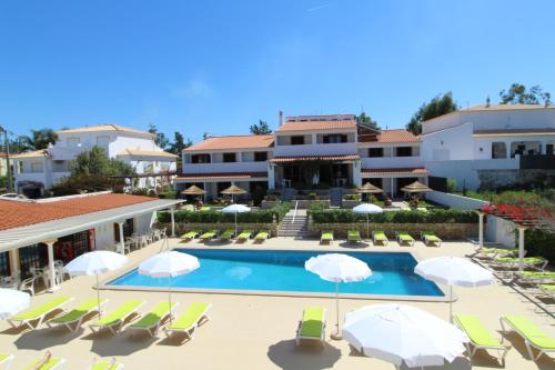 uma vista para a piscina num resort com cadeiras e guarda-sóis em Balaia Sol Holiday Club em Albufeira