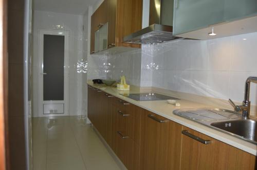 uma cozinha com armários de madeira e um lavatório e um lavatório em Apartamento con vistas en Cambados em Cambados