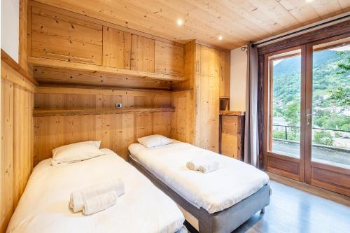 two beds in a room with a window at Apartment Bettex Splendide in Saint-Gervais-les-Bains