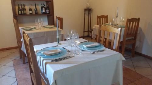 a dining room with a white table with plates and wine glasses at Locanda del Borgo in Prunetto