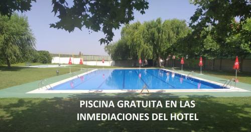 a swimming pool in a park with the words en las imagined at Hotel Plaza Manjón in Villanueva del Arzobispo