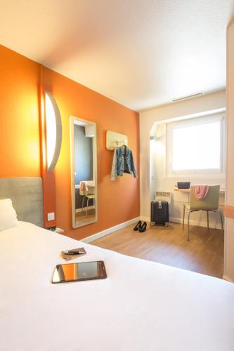 a hotel room with a bed and a desk at ibis budget Vienne Sud in Vienne
