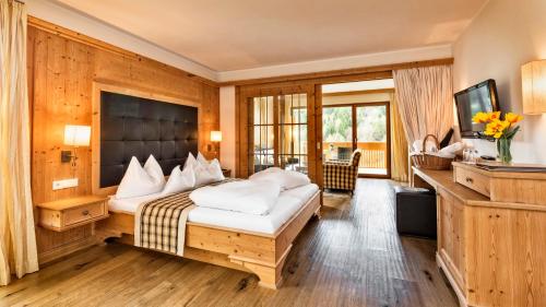 a hotel room with a bed and a television at Hotel Sulfner in Avelengo