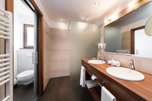 a bathroom with two sinks and a mirror at Hotel Sulfner in Avelengo