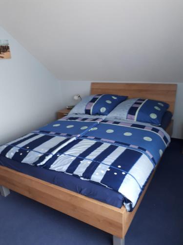 a bed with a blue and white comforter and pillows at Ferienwohnung Steffi in Andernach