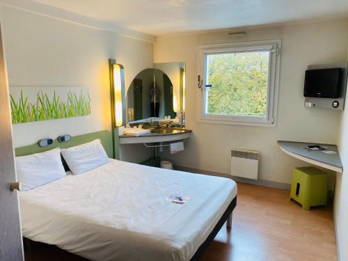 een slaapkamer met een bed, een wastafel en een raam bij ibis Budget Caen Centre Gare in Caen