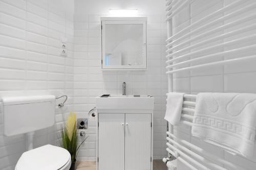 a white bathroom with a toilet and a sink at BpR COSMOS Design Suite with A/C in Budapest