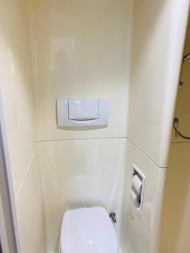 a small bathroom with a white toilet in an airplane at ibis Budget Caen Centre Gare in Caen