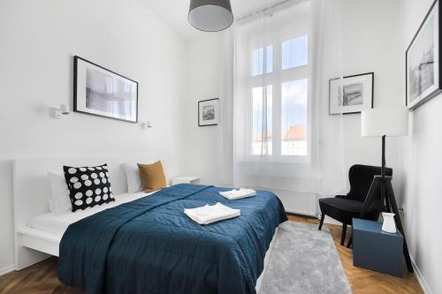 a white bedroom with a bed and a chair at BpR COSMOS Design Suite with A/C in Budapest