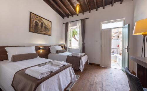 a hotel room with two beds and a window at La Regina Veneziana in Mağusa