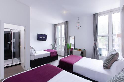a hotel room with two beds and a window at Amra Barcelona Caspe in Barcelona
