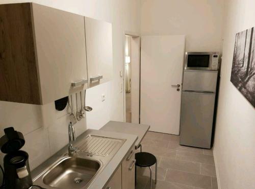 eine kleine Küche mit Spüle und Kühlschrank in der Unterkunft Altenbeken- Ferienwohnung in Altenbeken