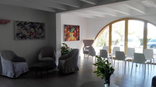 a waiting room with chairs and tables and a large window at La Casa nel Verde in Larino