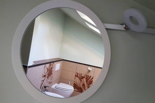 ein Badezimmer mit einem weißen WC und einem Spiegel in der Unterkunft Cozy loft in Rijeka