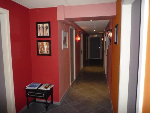 a room with a red wall and a blue door at Hotel Du Centre in Hagondange