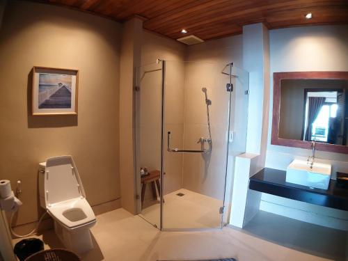 a bathroom with a shower and a toilet and a sink at Salad Hut in Salad Beach