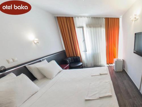 a hotel room with a white bed and a television at Hotel Balca in Izmir