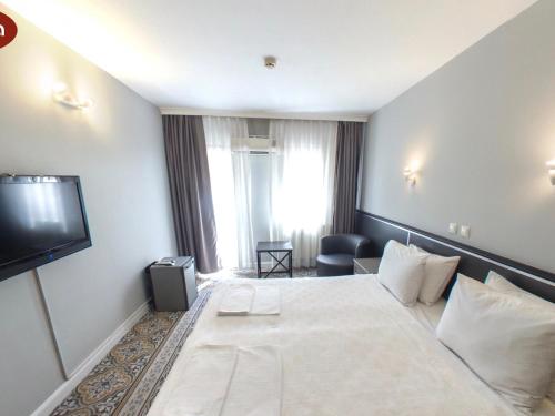 a hotel room with a large bed and a television at Hotel Balca in Izmir
