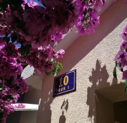 ミルナにあるApartmani Ritaの紫の花の建物側時計