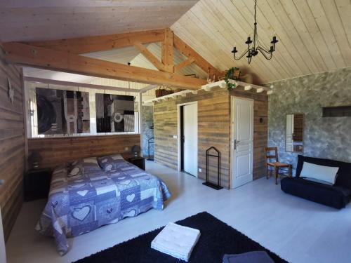 ein Schlafzimmer mit einem Bett und einem Stuhl in einem Zimmer in der Unterkunft Le Moulin de la Fortie, maison d'hôtes in Viscomtat