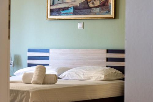 a bedroom with a bed with a painting on the wall at Irini Apartments in Kavala