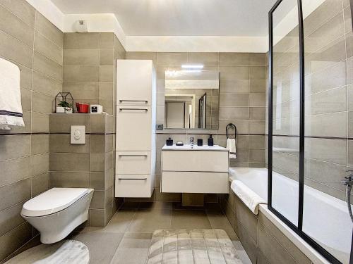 une salle de bain avec toilettes, lavabo et baignoire dans l'établissement Apartment Palm Beach with a nice swimming pool, à Cannes