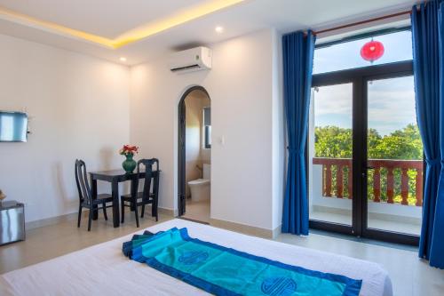 a bedroom with a bed and a table and a window at Hoi An Village Villa in Hoi An