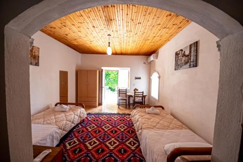 a room with two beds and a room with a table at Guest House Garden in Gjirokastër