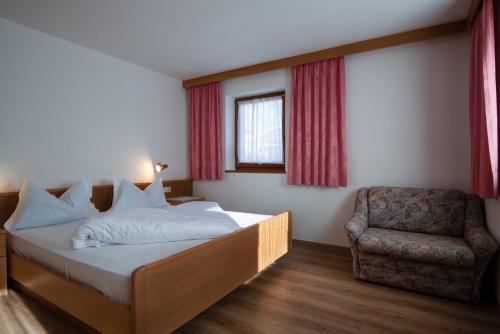 1 dormitorio con 1 cama y 1 silla en Apartment 1 - Zur Sonne, en Laion