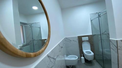 a bathroom with a mirror and a toilet at Mille Amici Hotel in Shëngjin