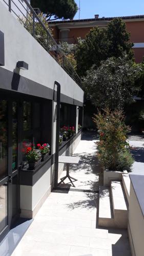 a bench sitting outside of a building with flowers at Hotel Villa MIKI in Bordighera