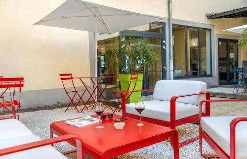 a patio with chairs and a table with glasses of wine at ibis Lyon Sud Vienne Saint-Louis in Vienne