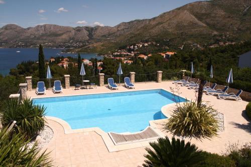 a swimming pool with chairs and a view of the water at Villa Alegria Cavtat in Cavtat