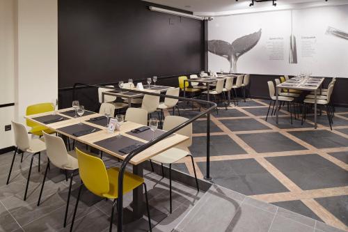 a dining room with tables and chairs and a chalkboard at Pensión Txiki Polit in Zarautz