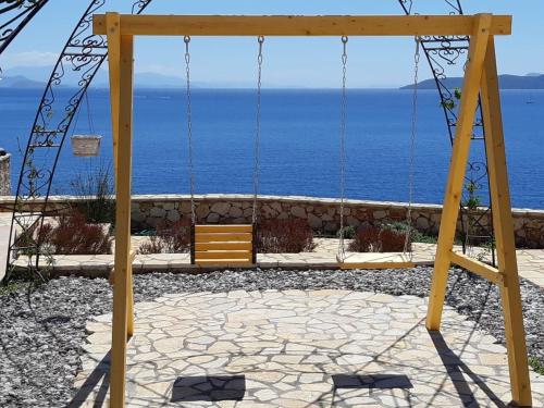 a swing with the ocean in the background at Villa LeSunLuka Lefkada in Vasiliki
