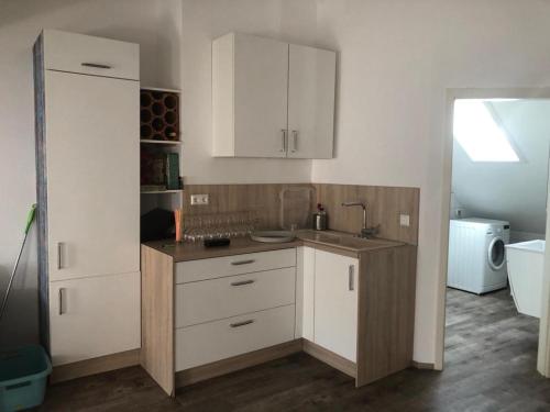 eine Küche mit weißen Schränken und einem Waschbecken in der Unterkunft Old Bridge View Apartment in Heidelberg