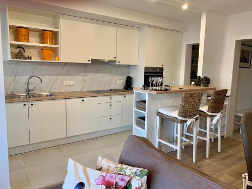a kitchen with white cabinets and a table and chairs at Residentie Rapallo Oostende with fantastic Sea View! in Ostend
