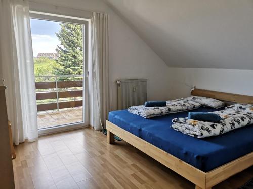 - une chambre avec 2 lits et une grande fenêtre dans l'établissement Ferienwohnung "Weinbergblick" im Winzerdorf, à Leinsweiler
