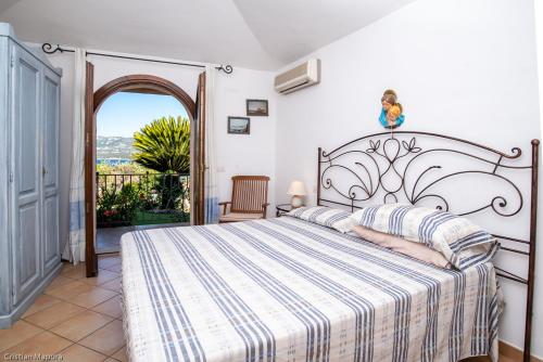 a bedroom with a large bed and an open doorway at villa smeralda in Cannigione