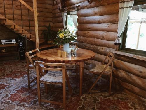 una mesa de madera y sillas en una cabaña de madera en Namelis Atokvėpis, en Čiuiniukai