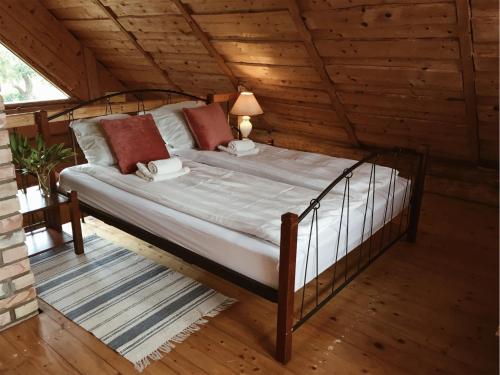 a bedroom with a bed in a wooden room at Namelis Atokvėpis in Čiuiniukai